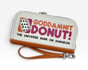 May include: A white and orange rectangular wristlet wallet with a zipper closure and a detachable wrist strap. The front features a graphic with the text GODDAMNIT DONUT! THE UNIVERSE RUNS ON DUNGEON and a small icon of a playing card.