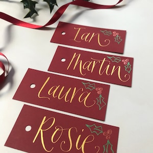 4 Personalised Christmas Red gift tags for gift wrapping, present labels, hand written with calligraphy in gold ink and a holly decoration