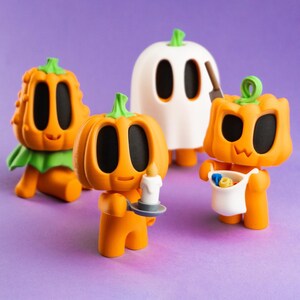 May include: Four Halloween-themed figurines on a purple background. The figurines include three orange pumpkin characters and a white ghost figure. One pumpkin holds a candle, another a bag of treats, and the third is sitting. The ghost holds a knife.