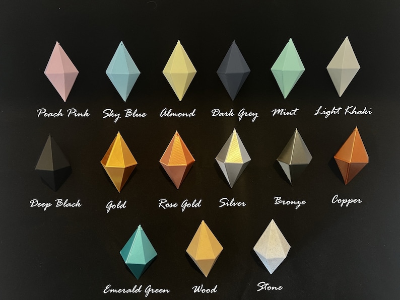 May include: A chart of 15 different coloured diamond-shaped ornaments. The colours include peach pink, sky blue, almond, dark grey, mint, light khaki, deep black, gold, rose gold, silver, bronze, copper, emerald green, wood, and stone.