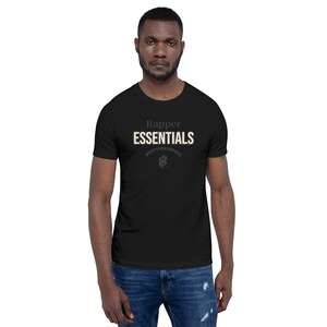 Pode incluir: Camiseta preta de manga curta com o texto "Rapper Essentials" em branco e um pequeno gráfico de um sinal de dólar com o texto "#PAYTHERAPPERS" abaixo.