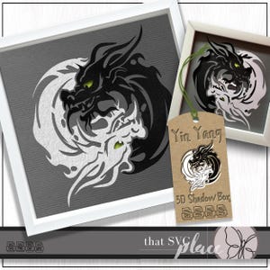 Pode incluir: Um símbolo Yin Yang preto e branco com um design de dragão. O símbolo está emoldurado em uma moldura branca e tem uma etiqueta marrom com o texto "Yin Yang" e "3D Shadow Box".