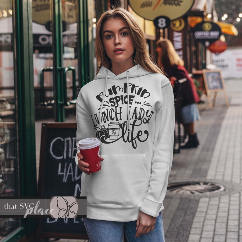 K&ouml;nnte beinhalten: Ein wei&szlig;er Hoodie mit einem schwarzen Aufdruck, der "Pumpkin Spice...Lunch Lady Life" mit einem kleinen K&uuml;rbis- und Kaffeetassen-Design sagt.