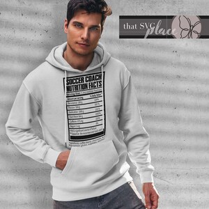 May include: A white hooded sweatshirt with a black graphic print of a nutrition facts label for a soccer coach. The label lists various attributes like persistence, passion, dedication, hard work, caffeine, and regret. The text "Soccer Coach Nutrition Facts" is at the top of the label.