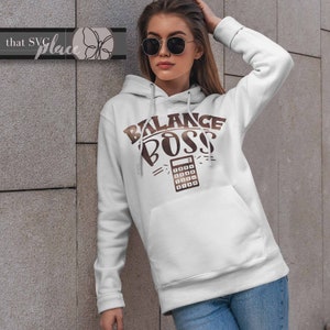 May include: White hoodie with a brown graphic that says "Balance Boss" with a calculator underneath.