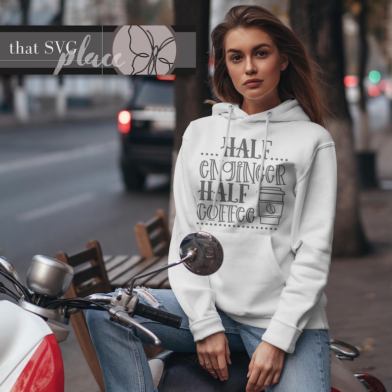 Op de afbeelding: Witte hoodie met een grijze afbeelding met de tekst "Half Engineer Half Coffee" met een koffiebekericoon.