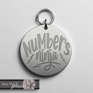 May include: Silver keychain with a round tag that says "Numbers ninja" in a stylized font.