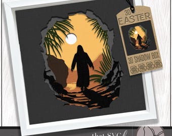 May include: A framed 3D shadow box with an Easter theme. The artwork depicts a silhouette of a person walking towards a bright sunlit area, framed by a torn-paper effect. The color palette includes black, brown, yellow, and green. A tag reads "3D Easter 3D Shadow Box".