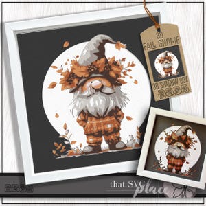 May include: Framed artwork featuring a whimsical gnome illustration. The gnome is depicted with a long white beard, a gray hat, and an orange plaid outfit, surrounded by autumn leaves. The artwork is set against a black background with a white circle.