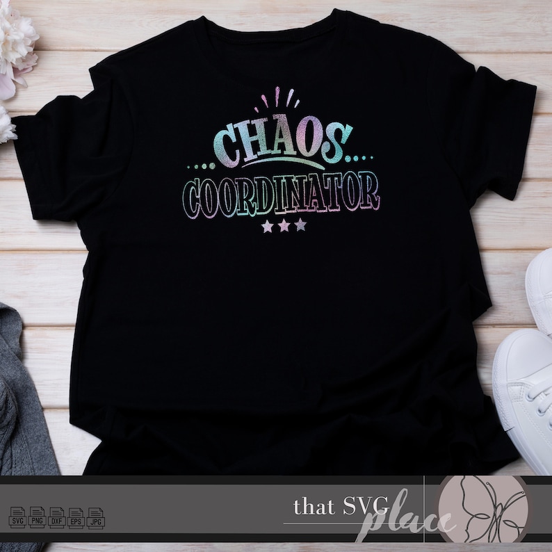 May include: Black t-shirt with a rainbow iridescent design that says "...CHAOS... COORDINATOR" with three stars underneath.