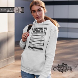 Op de afbeelding: Witte hoodie met een zwarte afbeelding van een voedingsschema met de tekst "Receptionist Nutrition Facts". Het schema somt verschillende eigenschappen op zoals doorzettingsvermogen, passie, toewijding, hard werken, cafe&iuml;ne en spijt, met percentages naast elk.