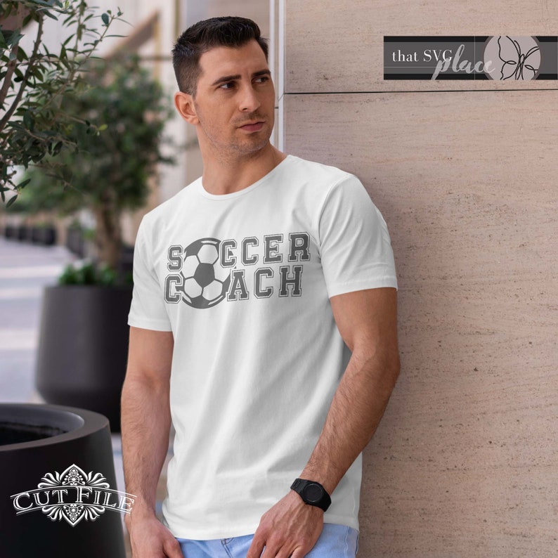 May include: A white t-shirt with a gray soccer ball and the text "SOCCER COACH" in a varsity style font.