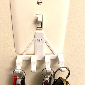 Multi-Use Hooks that easily mount on light switch panel to conveniently hold your keys, masks, or any other small item.