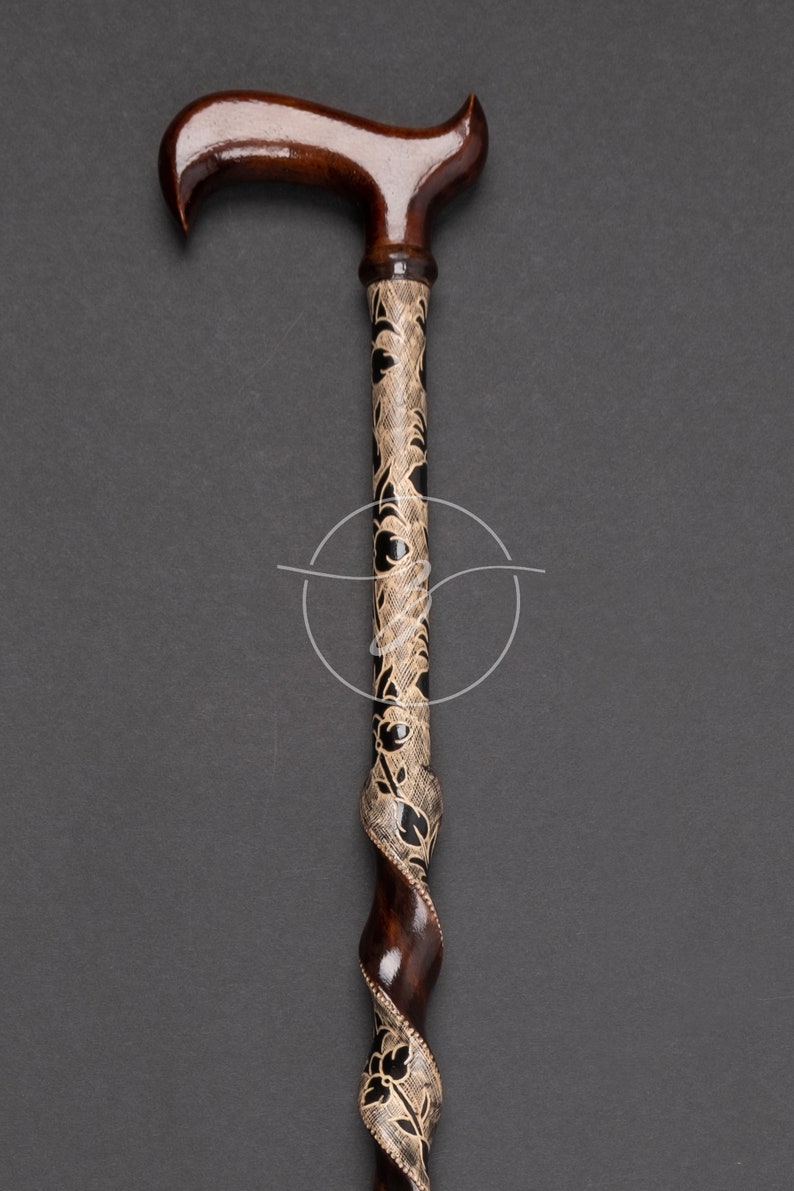K&ouml;nnte beinhalten: Ein Gehstock aus Holz mit einem braunen Griff und einem schwarz-cremefarbenen Schaft.