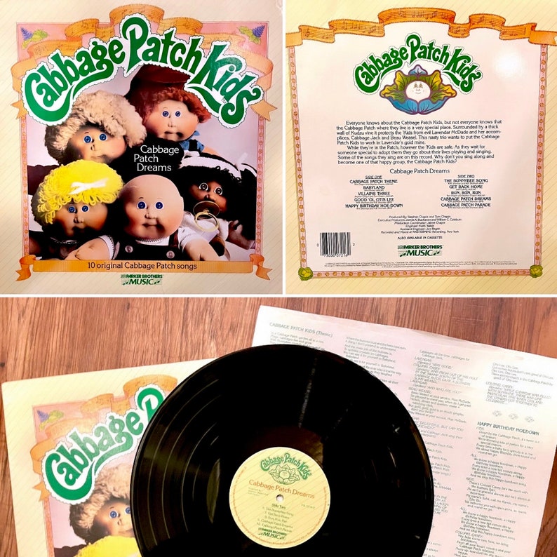 May include: A vintage vinyl record album cover featuring Cabbage Patch Kids dolls. The cover is yellow with a green title, "Cabbage Patch Kids". The album is titled "Cabbage Patch Dreams" and features 10 original Cabbage Patch songs.