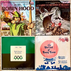 May include: Four vintage record albums with colourful covers. The top left album features Robin Hood, the top right album features a journey to the centre of the earth, the bottom left album features Ruth Sawyer Storyteller, and the bottom right album features the Ballad of Lucy Lum.