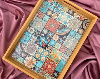 May include: A wooden serving tray with a colorful patterned design featuring geometric shapes and floral motifs. The tray has a light brown wood frame and a clear glass insert with the design printed on it.