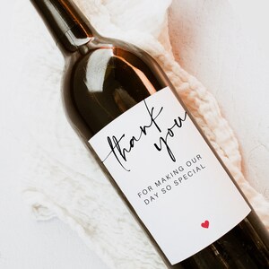 May include: A white wine bottle label with black calligraphy that reads "thank you" and "for making our day so special". A small red heart is in the bottom right corner.