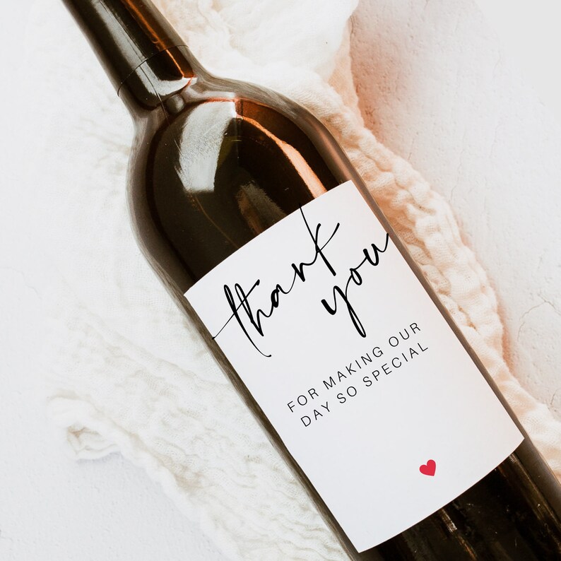 May include: A white wine bottle label with black calligraphy that reads "thank you" and "for making our day so special". A small red heart is in the bottom right corner.