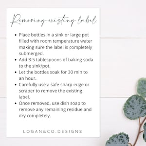 May include: A white card with black text outlining steps for removing existing labels from bottles. The steps include soaking the bottles in water and baking soda, then using a scraper to remove the label. The card also includes instructions for removing any remaining residue with dish soap. The text at the bottom of the card reads "LOGAN&CO. DESIGNS".