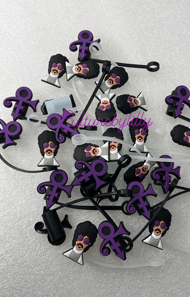 May include: A group of purple and black cable ties with a Prince symbol and a cartoon image of Prince wearing sunglasses. The cable ties are on a white surface.