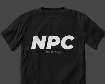 May include: Black crew neck t-shirt with the white letters "NPC" across the chest. Below the letters is the text "PRESS TO TALK" in white. The shirt is displayed on a dark grey background.