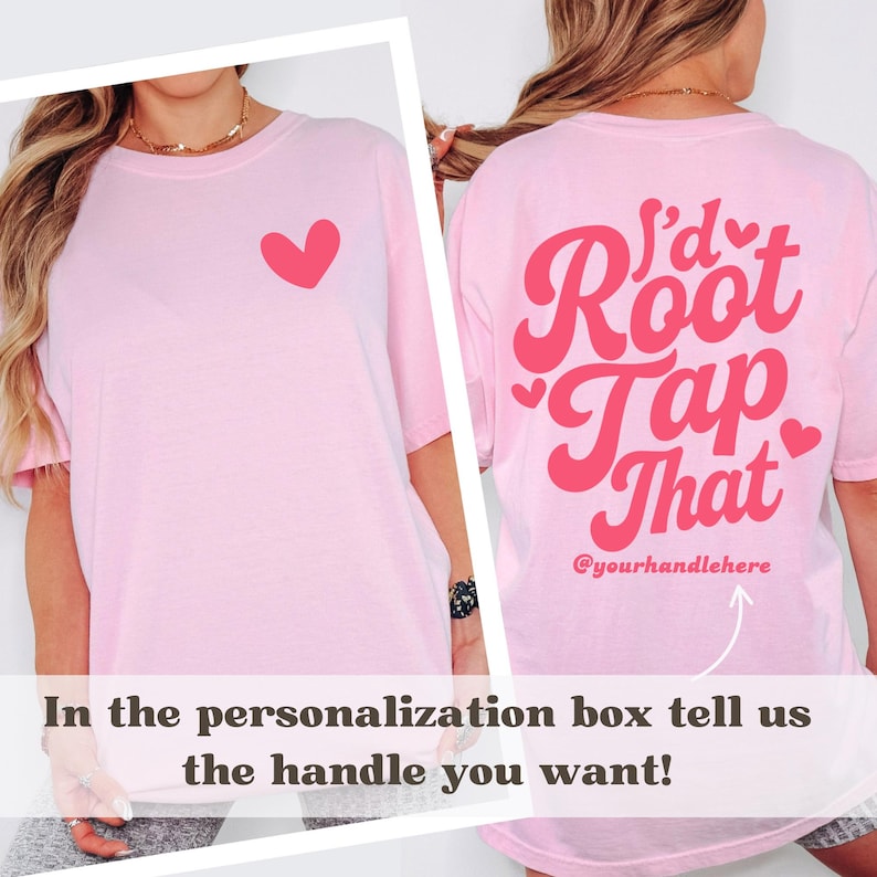 Puede incluir: Camiseta rosa claro con un coraz&oacute;n rojo en la parte delantera y la frase "I'd Root Tap That" en la parte trasera. El texto "@yourhandlehere" tambi&eacute;n est&aacute; en la parte trasera. La camiseta tiene mangas cortas.