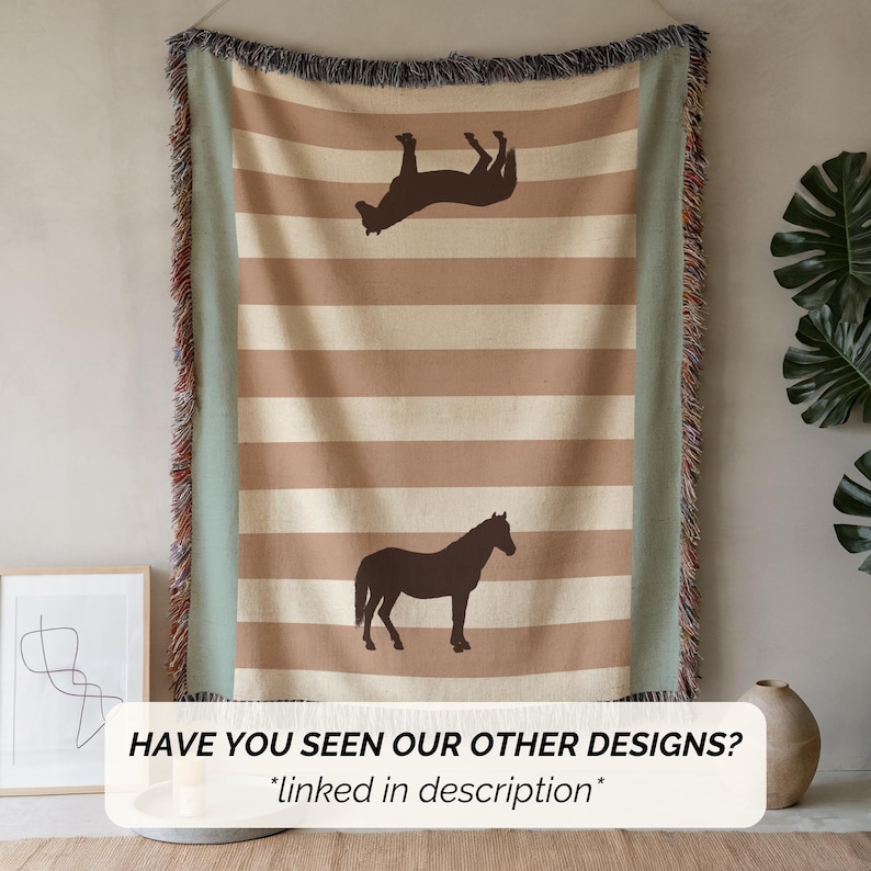 May include: A beige and brown striped throw blanket with a horse silhouette design. The blanket has a fringe border and a light green edge. The text "HAVE YOU SEEN OUR OTHER DESIGNS? *linked in description*" is at the bottom.