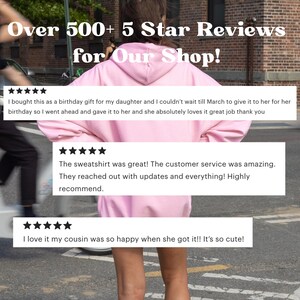 Puede incluir: Una persona lleva una sudadera con capucha rosa claro. La imagen incluye el texto "Over 500+ 5 Star Reviews for Our Shop!" y rese&ntilde;as de clientes.