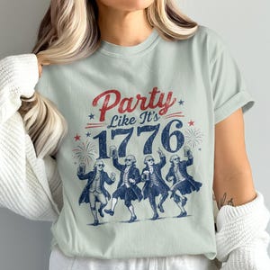 T-shirt with "Party Like It's 1776" and dancing historical figures holding mugs.