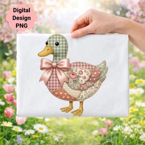 Op de afbeelding: Een patchwork eendenontwerp met een roze strik, met bloemen-, ruit- en hartpatronen. De eend heeft een groen en bruin geruite kop en een gele snavel en poten. De tekst "Digital Design PNG" staat in een roze wolk.
