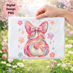 Könnte beinhalten: Ein weißes rechteckiges Design mit einer farbenfrohen Corgi-Illustration, Schleife, Herz und floralen Akzenten. Das Design enthält den Text "Digital Design PNG" in einem rosa Wolken-Textfeld. Der Corgi ist in lebendigen Regenbogenfarben dargestellt.