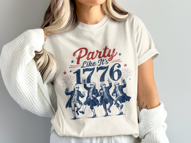 White t-shirt with "Party Like It's 1776" and graphic of dancing founding fathers holding beers.