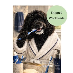 Könnte beinhalten: Ein schwarzer Hund in einem weißen Bademantel mit blauen Verzierungen putzt sich vor einem Spiegel die Zähne. Eine Tube Zahnpasta, eine Zahnbürste und eine Flasche Ocean Mist Handwaschmittel sind zu sehen. Im Hintergrund hängt ein blaues Handtuch.