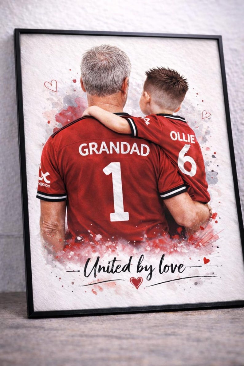 May include: Framed art print featuring a watercolor style image of a grandfather and grandchild in matching red jerseys. The jerseys display "GRANDAD 1" and "OLLIE 6". The text "United by love" is written below.