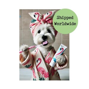 May include: A white dog wearing a pink flamingo print robe and a pink flamingo print headband is brushing its teeth with a pink toothbrush and a blue and white tube of toothpaste. The dog is looking directly at the camera.