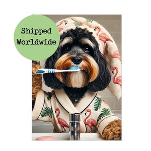 May include: A dog wearing a flamingo-patterned robe and towel, brushing its teeth with a blue and white toothbrush. The robe has a cream background with pink flamingos and green leaves. The dog has black and brown fur.