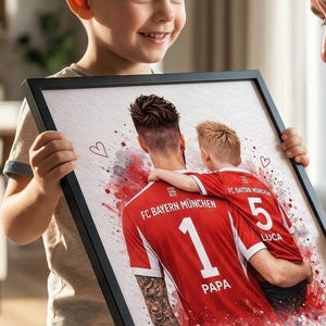 May include: A framed print featuring a watercolor-style illustration of two people in FC Bayern M&uuml;nchen jerseys. The jersey numbers are 1 and 5, with the names "PAPA" and "LUCA" below. The text "Mia San Mia" is also visible.