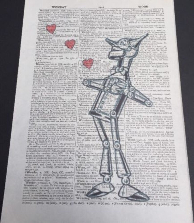 Pu&ograve; includere: Un'illustrazione in bianco e nero dell'Omino di Latta del Mago di Oz, disegnata su una pagina di dizionario vintage. La pagina presenta la parola "Wombat" e la parola "Wood". Tre cuori rossi sono disegnati intorno all'Omino di Latta.