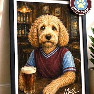 Könnte beinhalten: Ein gerahmtes Porträt eines goldfarbenen, lockigen Hundes in einem bordeauxroten und hellblauen V-Ausschnitt-Shirt, der an einem Holztisch mit einem Glas Bier sitzt. Der Name Max steht in weißer Schreibschrift unten rechts auf dem Bild.