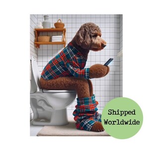 May include: A brown and white dog wearing a red and green plaid shirt and trousers sits on a white toilet in a bathroom. The dog is looking at a smartphone in its paws.