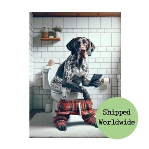 May include: A black and white dog wearing red and black plaid pyjamas sits on a white toilet in a bathroom with white tiled walls. The dog is holding a smartphone in its paws.