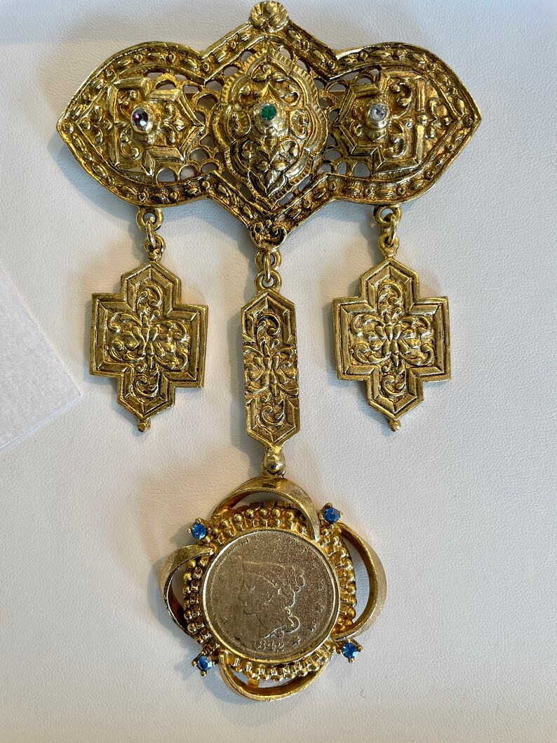 Vintage 1980’s dramatic, gold brooch, with coin and rhinestone details. shops A showstopper…