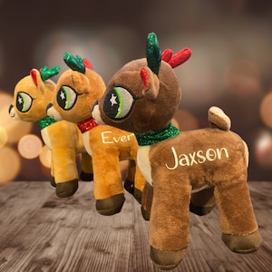 May include: Three plush reindeer toys with green antlers and red noses. The reindeer are brown and have embroidered names: "Ever", "Jaxson", and a third reindeer with an unreadable name.
