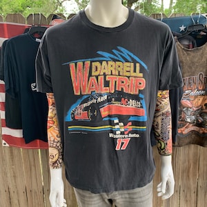 May include: Black t-shirt with a vintage Nascar design featuring Darrell Waltrip's name and the number 17. The design includes a red race car with Western Auto and AC Delco sponsors.