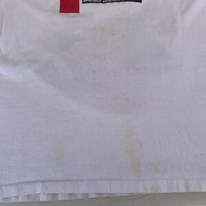 May include: White t-shirt with a red rectangle and the text "practice practice" on the top.