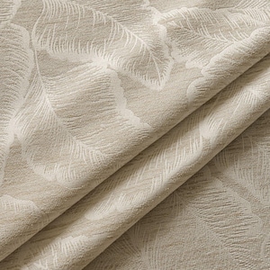 May include: Close-up of a beige fabric with a repeating feather pattern in a lighter beige color. The fabric is folded, showing the texture and design. The material appears to be a woven textile, suitable for upholstery or drapery.