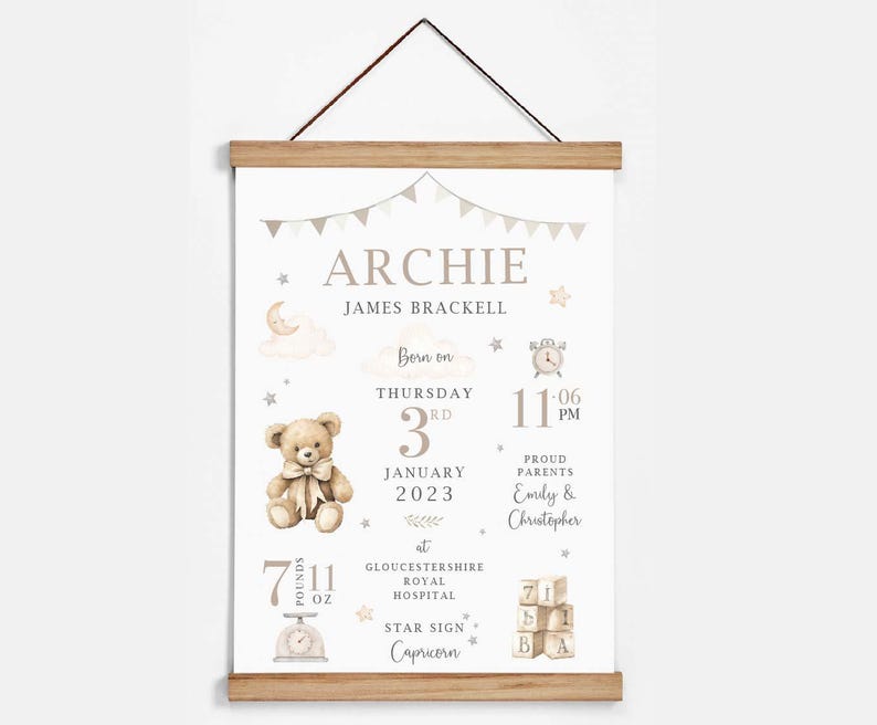 May include: A personalized baby birth announcement print with the name "ARCHIE" at the top. The print includes the baby's birth date, time, weight (7 lbs 11 oz), and star sign, Capricorn. The print is framed with a wooden hanger.