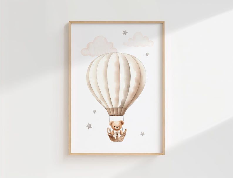 Pode incluir: Ilustra&ccedil;&atilde;o em aquarela de um bal&atilde;o de ar quente com um ursinho de pel&uacute;cia em uma cesta, em um fundo branco com nuvens e estrelas. A obra de arte &eacute; emoldurada em uma moldura de madeira clara, ideal para um quarto infantil.