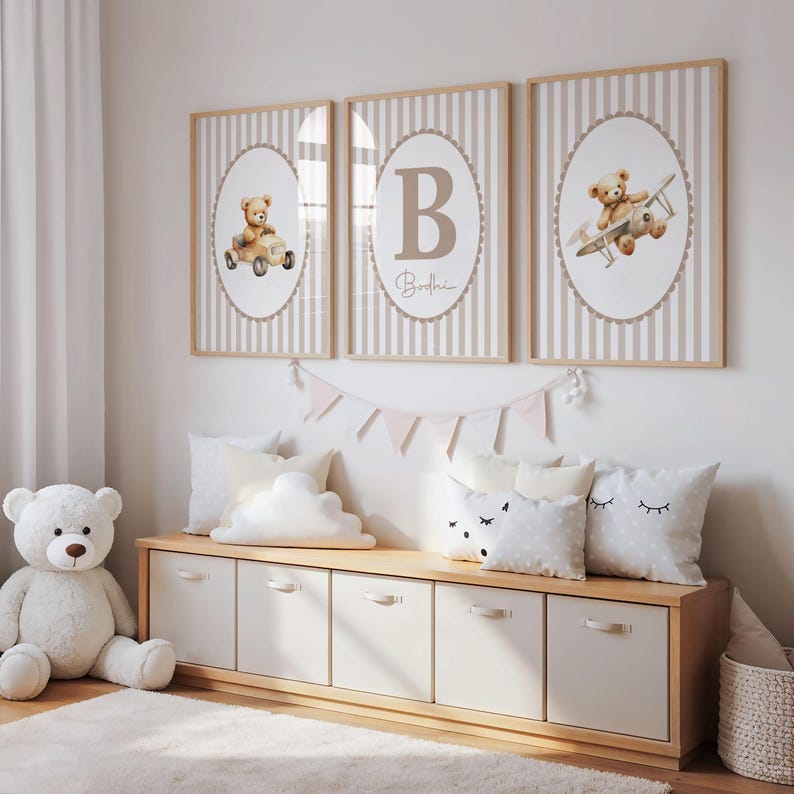 May include: Three framed nursery art prints with a teddy bear theme. Each print features a teddy bear in a car, airplane, or the letter "B" with the name "Bodhi". The prints have a striped background and are framed in light wood.